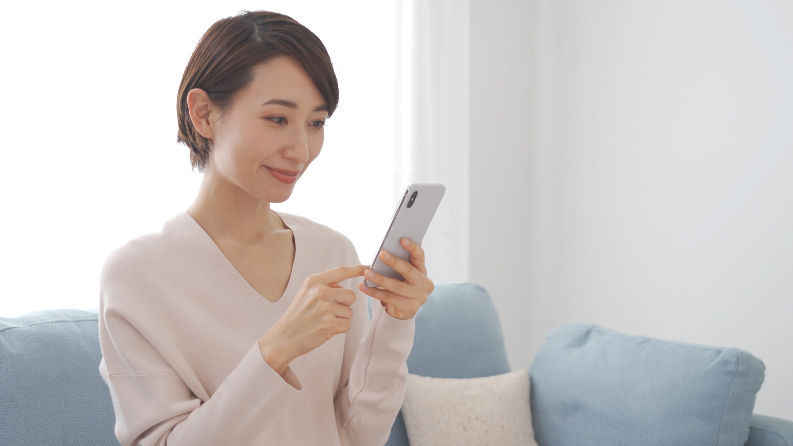 笑顔で携帯を触る日本人女性
